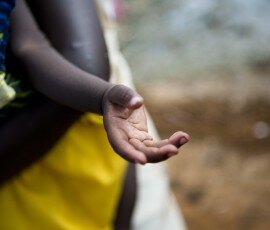 Ragina John, 28, and Rach Piny, 6 months, IDPs in Malakal camp, South Sudan. Ragina's son is sick with a chest infection, and Ragina is carrying medicine following a visit to the local hospital. Fighting has forced more than a million people from their hom